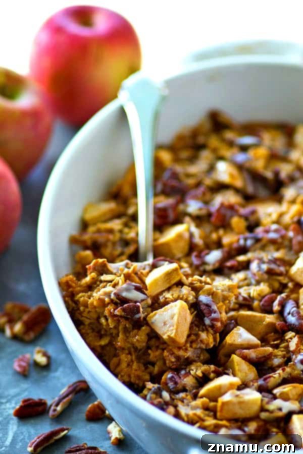 Apple Pie Oatmeal Bake 4 Overhead view of a whole pan of baked apple pie oatmeal, garnished with extra pecans and a generous drizzle of vanilla glaze.