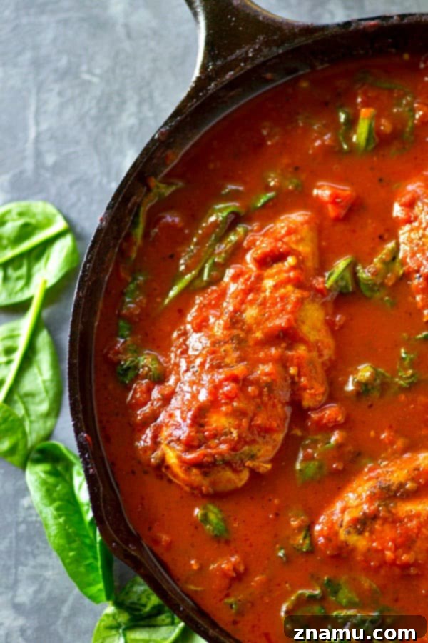 Tuscan Braised Chicken with Spinach and Tomato 3 Close-up of Italian Tomato Spinach Braised Chicken simmering in a pan