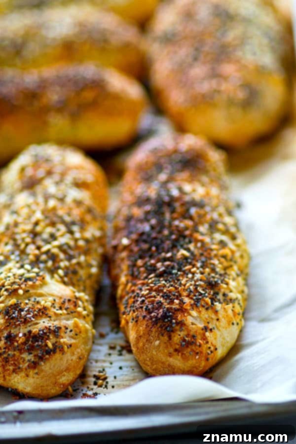 Overnight Everything Breadsticks 4 A freshly baked Everything Bagel Breadstick being held, showing its fluffy interior and crispy crust.