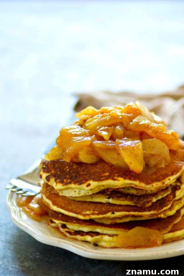 Brown Butter Cornmeal Stacks, Crowned with Apple-Pear Compote 3 Close-up of fluffy browned butter cornmeal pancakes generously topped with chunky apple pear compote and a dusting of cinnamon