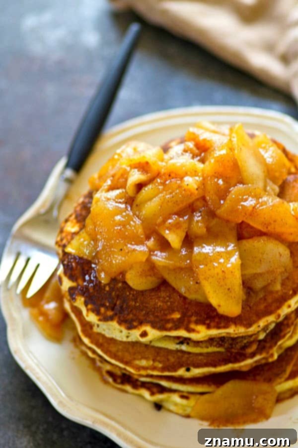Brown Butter Cornmeal Stacks, Crowned with Apple-Pear Compote 4 Freshly cooked browned butter cornmeal pancakes on a griddle, showing their golden-brown exterior and rustic texture