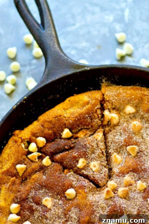 Pumpkin & White Chocolate Snickerdoodle Skillet 4 The cookie dough for the white chocolate pumpkin snickerdoodle skillet cookie being pressed into a cast iron skillet before baking.