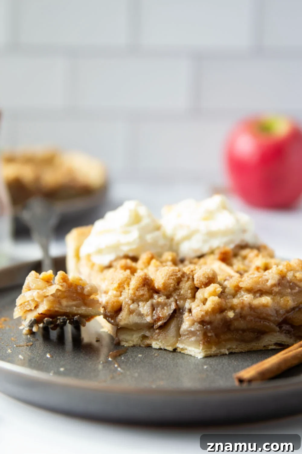 Overhead view of a baked apple slab pie, with some slices cut out and served.
