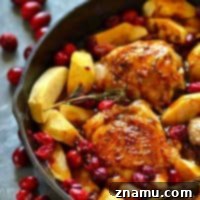 Juicy chicken thighs are roasted in tangy cranberries, soft apples, and covered in a sweet maple glaze for the EASIEST way to do chicken holiday-style!