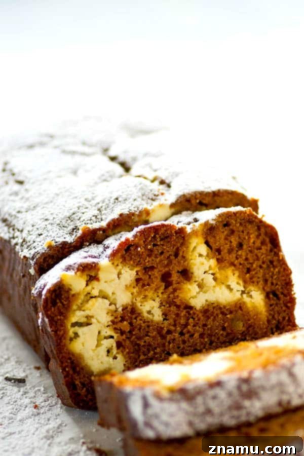 Marbled Gingerbread Cheesecake Bread 2 A freshly baked loaf of Gingerbread Cheesecake Swirl Quick Bread, showcasing a beautiful golden crust and a visible, creamy cheesecake swirl within its soft, spiced interior. Perfect for holiday brunch.