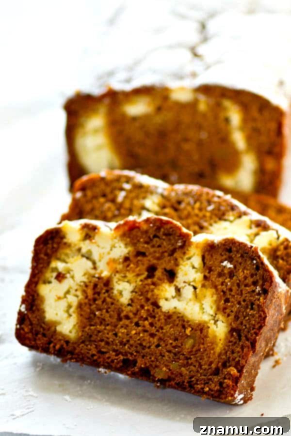 Marbled Gingerbread Cheesecake Bread 4 A beautifully baked Gingerbread Cheesecake Swirl Quick Bread, cooling on a wire rack, with a gentle dusting of powdered sugar. The intricate swirl is visible on the surface, hinting at the deliciousness within.