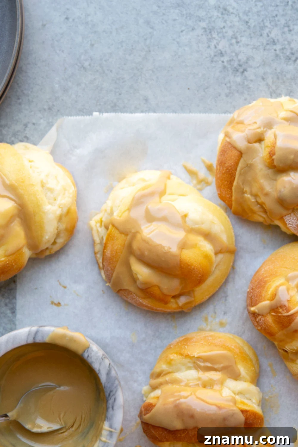 Decadent Cream Cheese Morning Buns with Coffee Glaze 4 Freshly baked cream cheese morning buns cooling on a wire rack, displaying their golden crust and fluffy texture before being glazed.