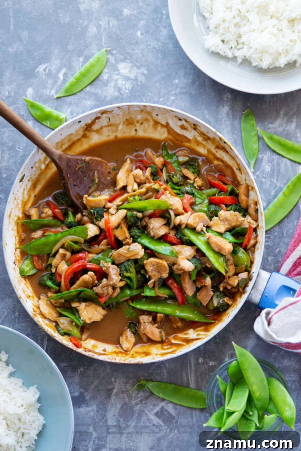 Sizzling Peanut Satay Chicken 4 Assorted fresh vegetables for a stir fry, including colorful bell peppers, broccoli florets, and snow peas, ready to be cooked and tossed in peanut sauce.