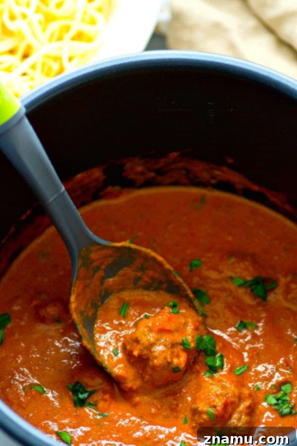 Open Instant Pot with red wine and crushed tomatoes added to browned meatballs, ready for pressure cooking