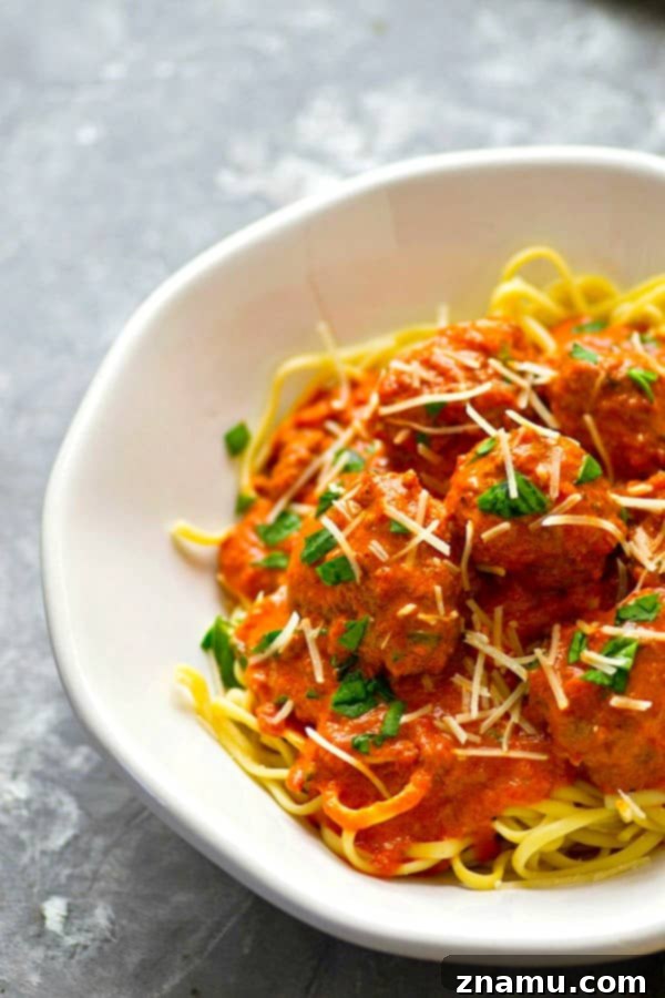 Platter of tender Instant Pot red wine marinara meatballs, garnished with fresh basil, ready to be served over pasta