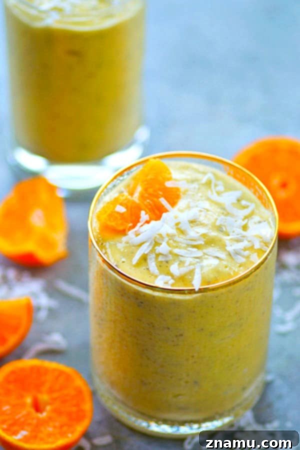Mango Tango Coconut Power Boost 3 Close-up of a Mango Orange Coconut Power Smoothie, showcasing its smooth texture and rich color, with tropical fruit ingredients like mango and orange visible in the background, emphasizing a refreshing and healthy meal or snack.