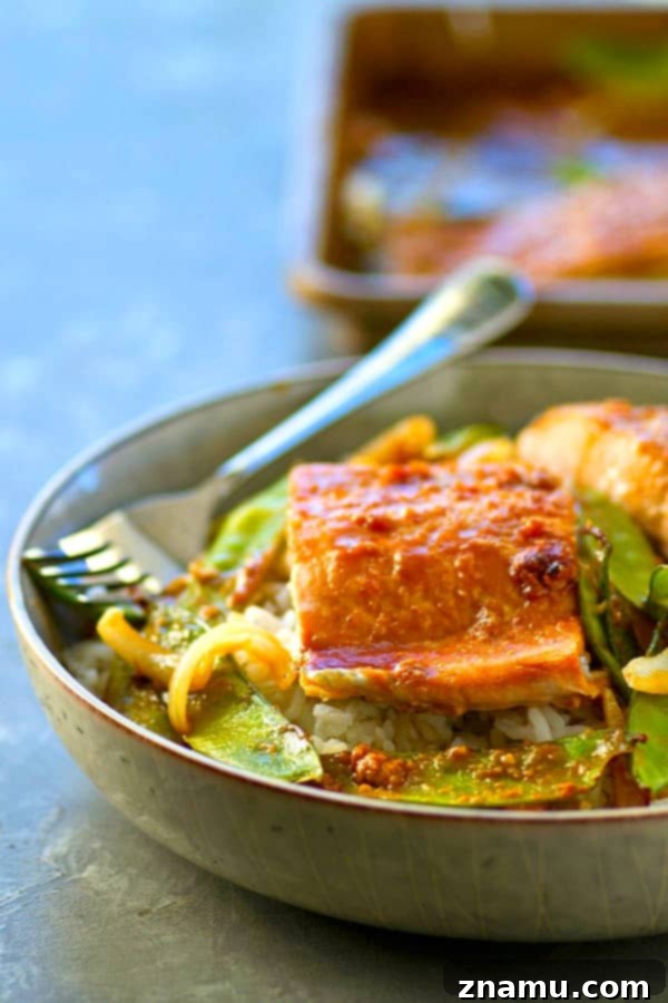 Easy One-Pan Hoisin Salmon and Snow Peas 4 Sheet pan with raw salmon fillets, snow peas, and sliced onions, ready to be coated with hoisin sauce.