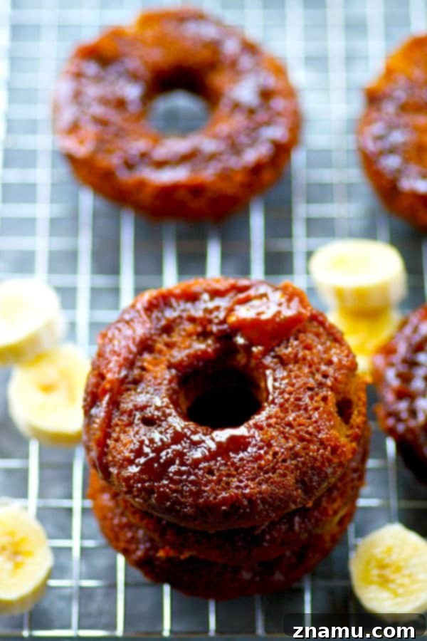 Sticky Caramel Banana Bread Bites 4 A beautifully composed shot of three baked banana bread donuts, with the homemade caramel glistening under soft light, ready to be enjoyed.