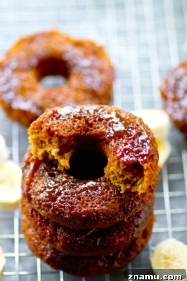 Sticky Caramel Banana Bread Bites 5 An overhead view of a selection of caramel upside-down banana bread donuts, some cut open to show the moist interior.