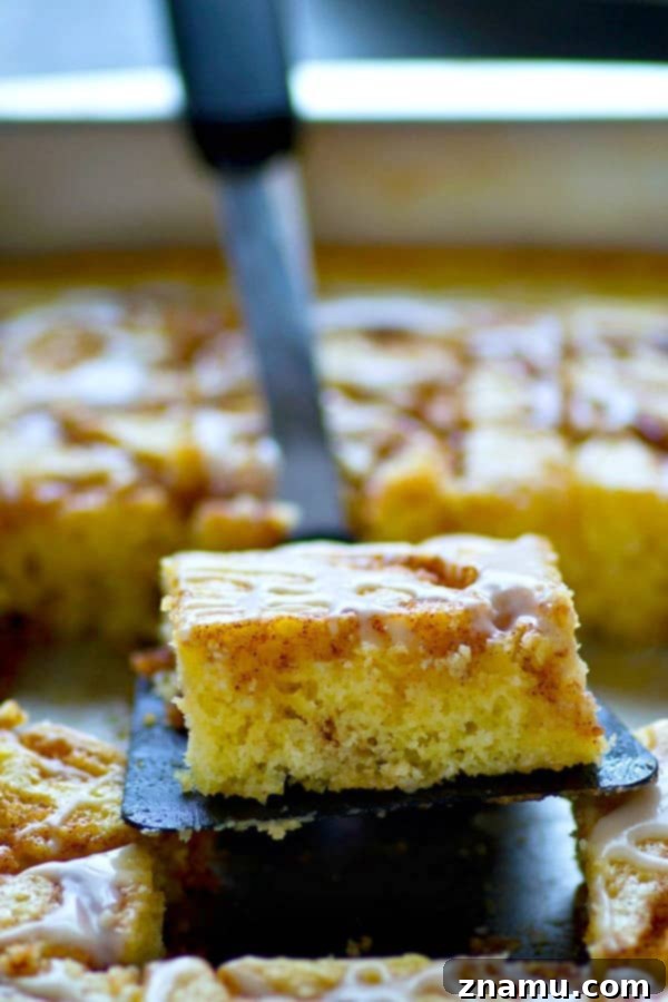 Cinnamon Swirl Sheet Delight 5 A glorious shot of the fully baked and glazed cinnamon roll swirl sheet cake, ready to be sliced