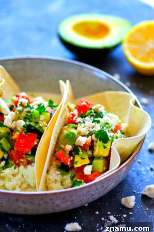 Mediterranean Morning Egg White Avocado Tacos 3 A close-up of Greek Avocado Egg White Breakfast Tacos, showcasing the fresh ingredients like avocado, tomato, cucumber, and feta.