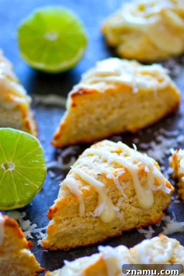 Key Lime Pie Coconut Scones 3 Close-up of a stack of buttery coconut key lime pie scones, glistening with glaze