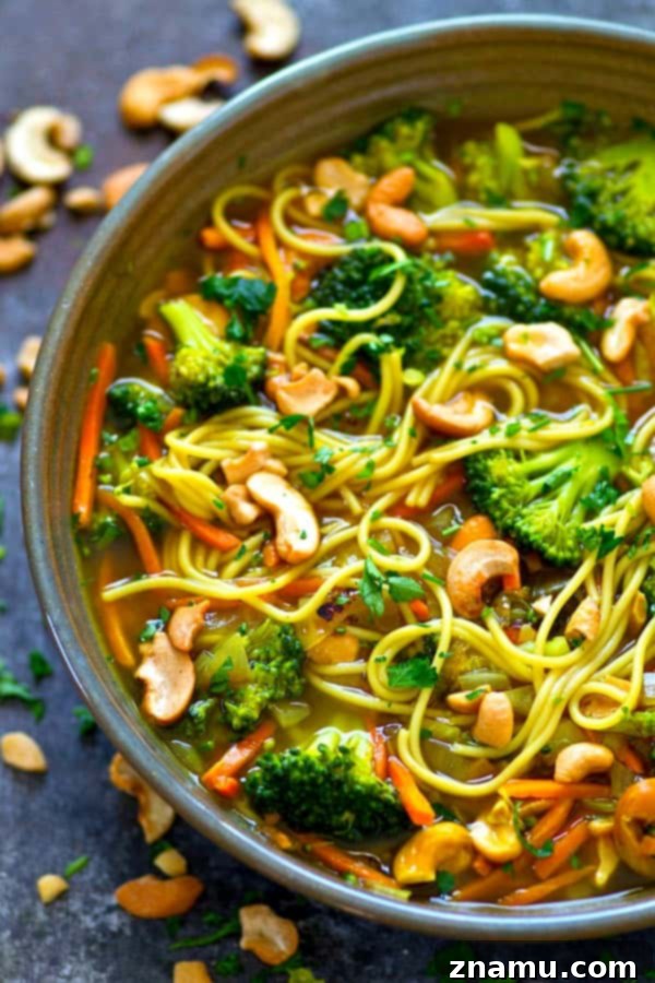Close-up of a beautiful Broccoli Cashew Curry Noodle Broth Bowl with vibrant vegetables.