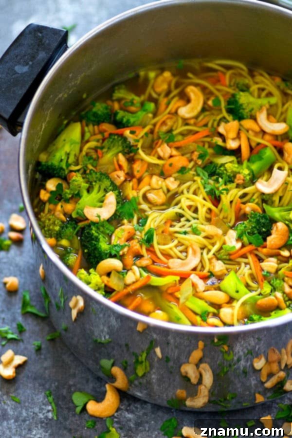 Overhead shot of a delicious Broccoli Cashew Curry Noodle Broth Bowl with toasted cashews.