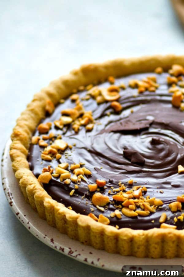 Indulgent Peanut Butter Chocolate Tart 3 A beautifully sliced peanut butter cookie chocolate ganache tart ready to be served.