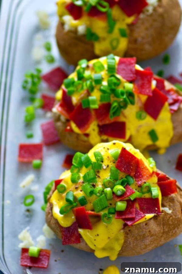Bacon Eggs Benedict Baked Potato 3 Close-up of fluffy baked potato topped with crispy bacon and creamy hollandaise