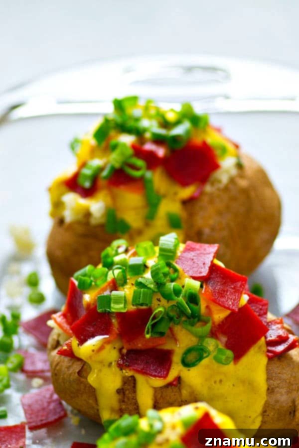 Bacon Eggs Benedict Baked Potato 5 Assembled Bacon Eggs Benedict Breakfast Baked Potato garnished with green onions