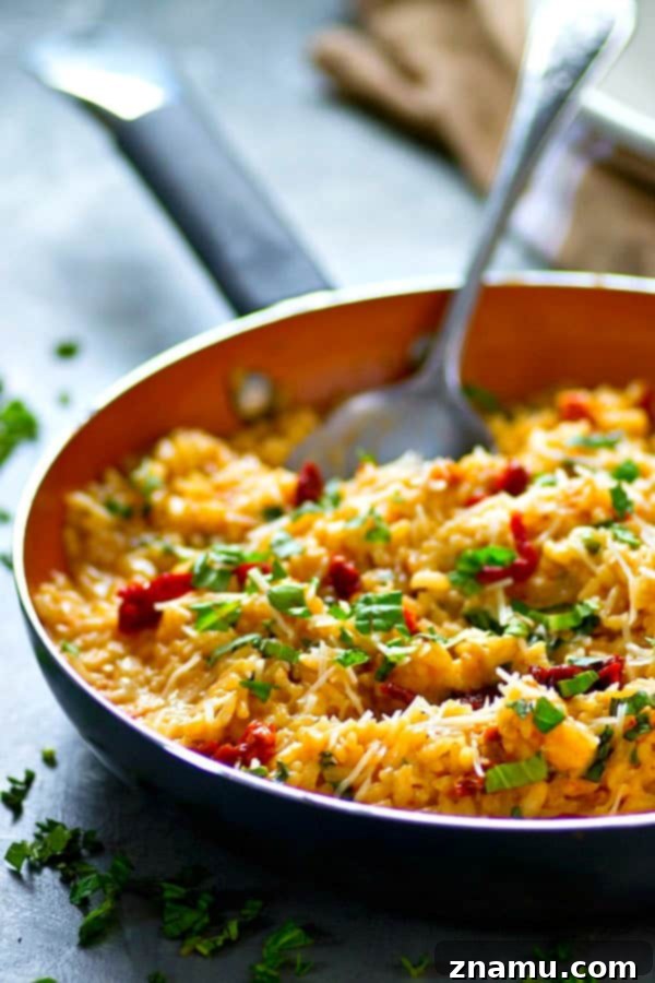 Sun-Dried Tomato, Basil & Cream Cheese Risotto 5 A large pot of Cream Cheese Basil Risotto with Sun-Dried Tomatoes, perfectly cooked and ready to be served, showcasing its vibrant colors and creamy texture.