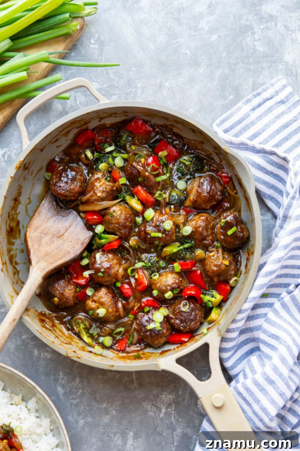 Mongolian Glazed Beef Bites 3 Close-up of glazed Mongolian Beef Meatballs with broccoli and peppers in a skillet.