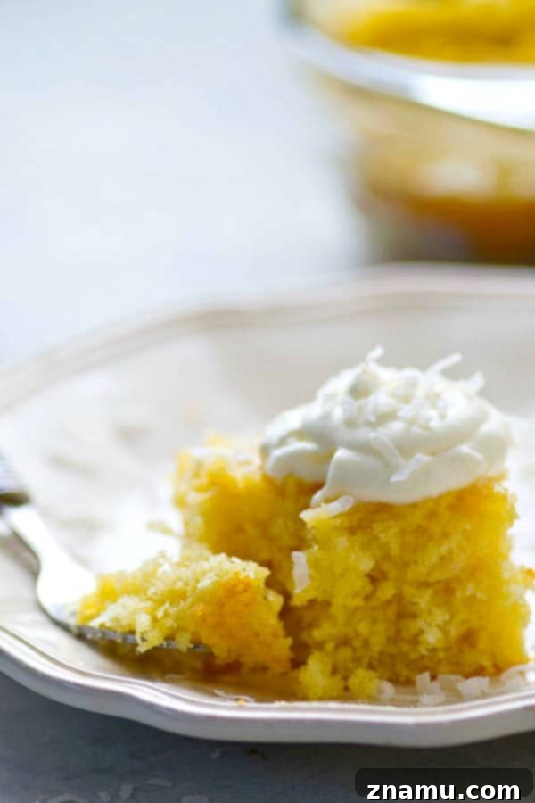 Pina Colada Escape Poke Cake 3 Close-up of a slice of Pina Colada Poke Cake showing its moist texture and glaze