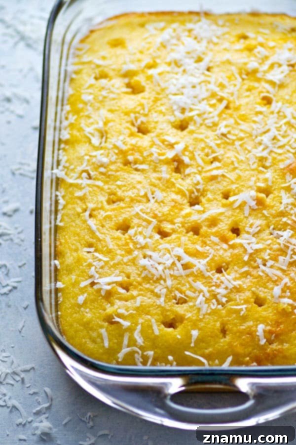 Pina Colada Escape Poke Cake 4 Pina Colada Poke Cake garnished with fresh pineapple and whipped cream