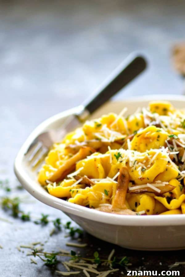 Rich garlic butter Asiago tortellini skillet with shiitake mushrooms, served hot.