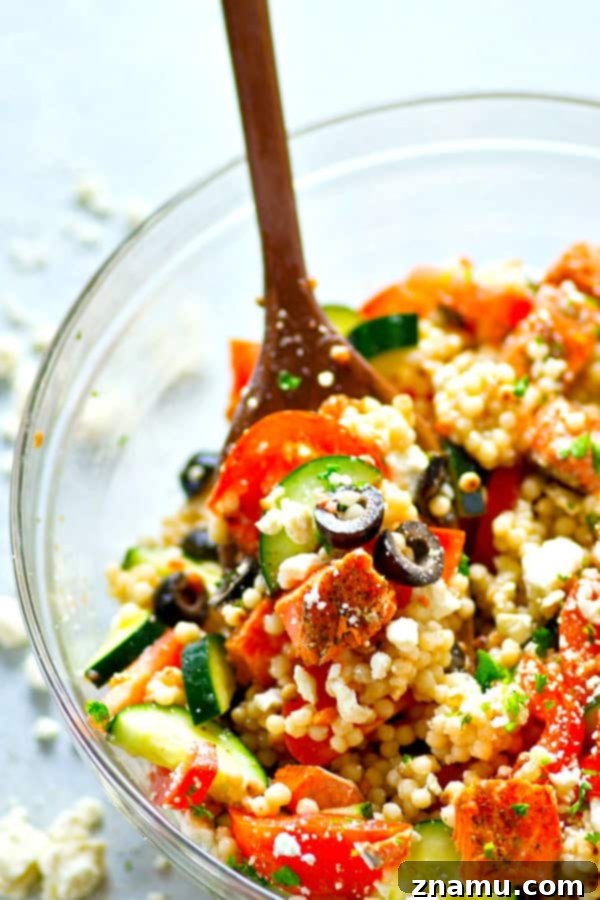 Side shot of the Greek Salmon Couscous Salad, highlighting the layers of fresh ingredients and dressing