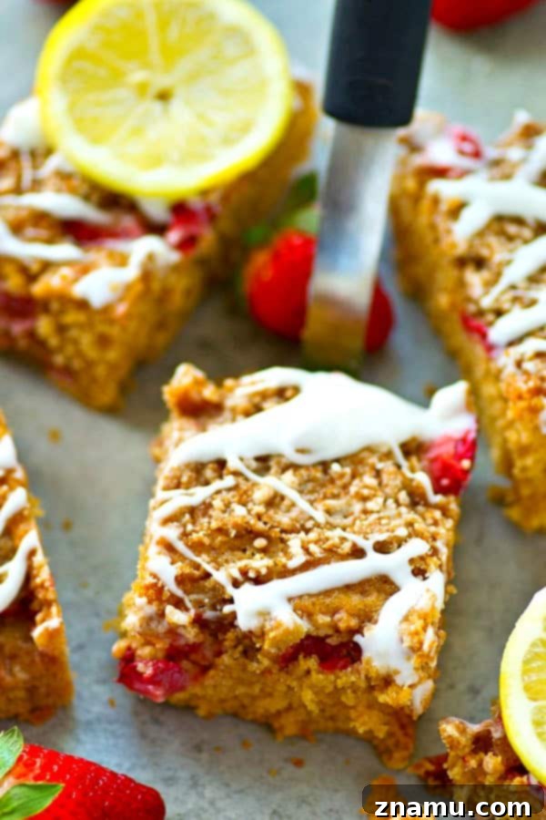 Sunshine Berry Crumb Coffee Cake 2 Stunning Strawberry Lemon Crumb Coffee Cake with fresh strawberries and lemon slices, drizzled with sweet lemon glaze, presented on a white serving plate – ideal for brunch or dessert.
