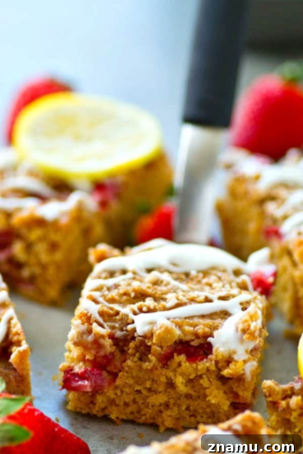 Sunshine Berry Crumb Coffee Cake 4 A large pan of freshly baked Strawberry Lemon Crumb Coffee Cake, glistening with lemon glaze and adorned with more fresh strawberries, ready to be sliced and served at brunch.