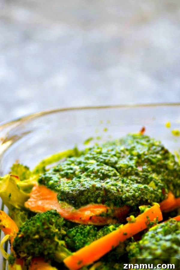 Delicious Pesto Baked Salmon with Broccoli and Sweet Peppers on a baking dish, a quick and healthy low-carb meal