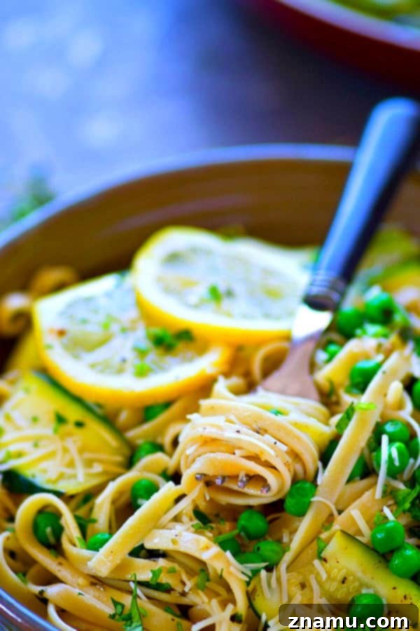 Bright Lemon Parmesan Fettuccine with Zucchini Ribbons and Spring Peas 5 A serving of Lemon Parmesan Fettuccine, highlighting the delicate zucchini ribbons and bright green peas.
