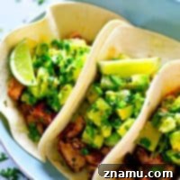 A smoky homemade jerk seasoning coats every inch of these jerk grilled salmon tacos that are heaped in soft flour tortillas and piled high with tangy avocado pineapple salsa!
