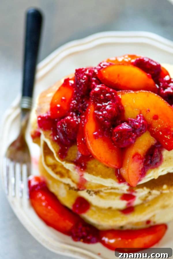 Heavenly Peach Raspberry Sour Cream Stacks 3 Fluffy sour cream pancakes ready to be topped with a juicy peach raspberry mixture
