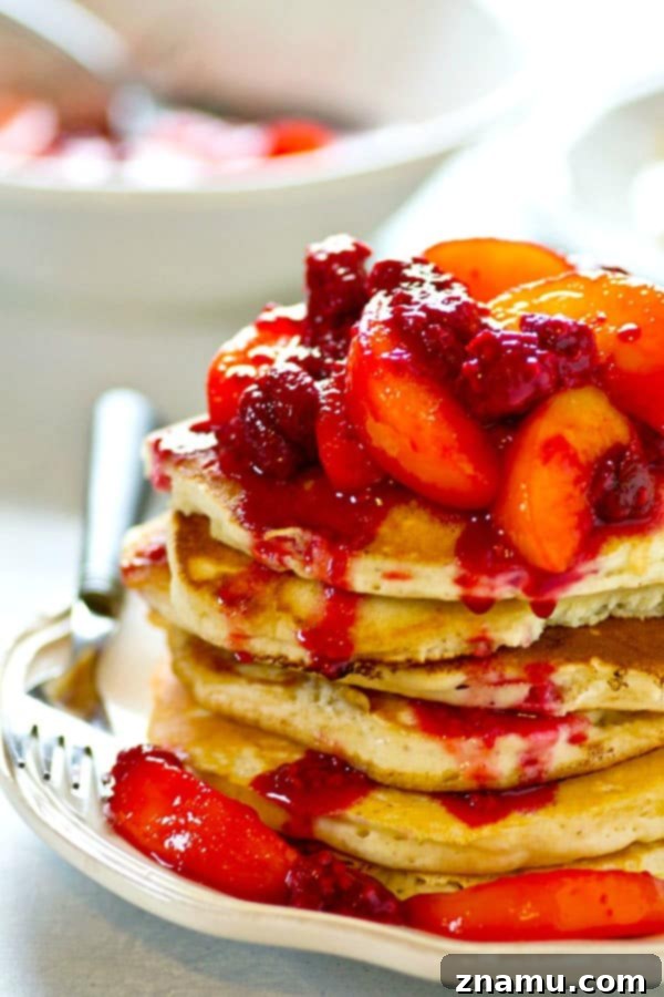Heavenly Peach Raspberry Sour Cream Stacks 4 Close-up of a stack of sour cream pancakes with rich peach raspberry topping