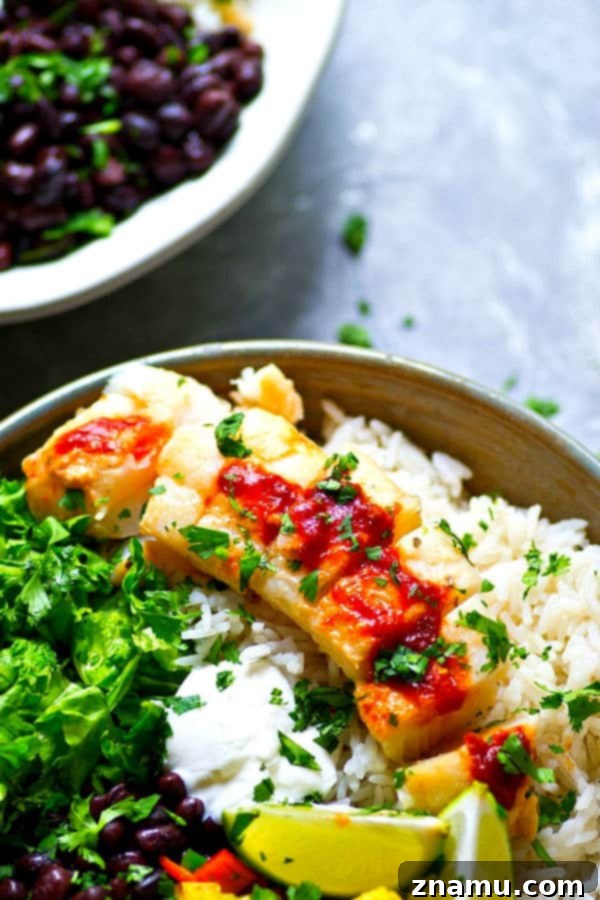 A close-up of a serving of Chipotle Fish Taco Rice Bowls, highlighting the textures and vibrant colors of the ingredients.
