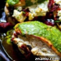 Chimichurri-Drizzled Chicken with Sun-Dried Tomato and Goat Cheese Stuffing 7 A single serving of sun-dried tomato goat cheese stuffed chicken with chimichurri on a plate.