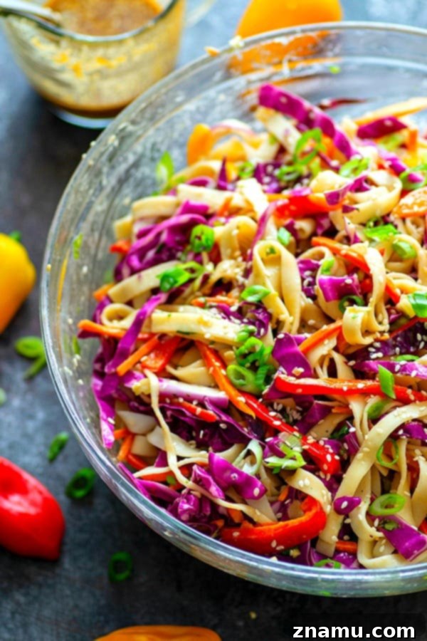 Overhead view of the colorful ingredients of the Peanut Sesame Thai Noodle Crunch Salad before mixing, highlighting fresh vegetables and noodles.