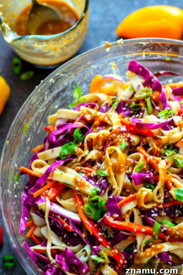 A serving of Peanut Sesame Thai Noodle Crunch Salad in a white bowl, ready to be enjoyed.
