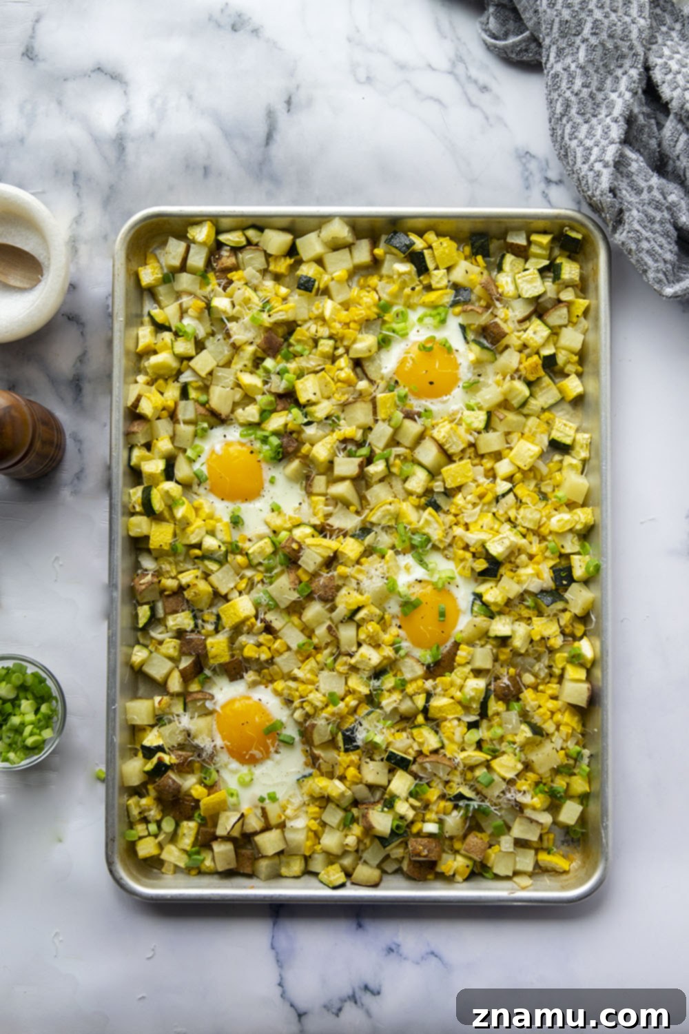 Sunny Summer Squash & Sweet Corn Sheet Pan Hash 3 Close-up of golden crispy potatoes and tender summer squash in a breakfast hash on a sheet pan.