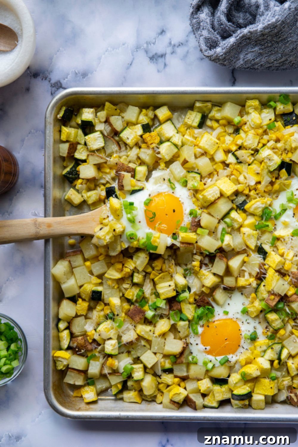 Sunny Summer Squash & Sweet Corn Sheet Pan Hash 6 A close-up shot of the finished Sheet Pan Sweet Corn Summer Squash Breakfast Hash, topped with Parmesan and green onions.