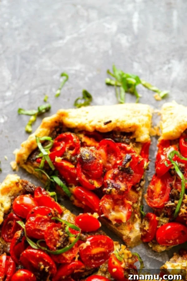 Ricotta Basil Pesto Cherry Tomato Tart 2 Delicious Ricotta Basil Pesto Cherry Tomato Galette on a rustic wooden board, showcasing its golden crust and juicy filling.