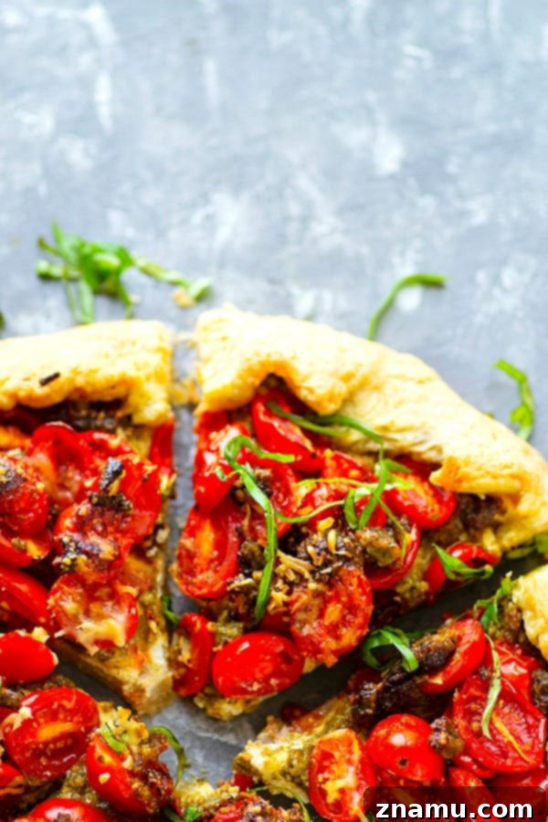Ricotta Basil Pesto Cherry Tomato Tart 5 A whole Ricotta Basil Pesto Cherry Tomato Galette, golden brown and garnished with fresh basil leaves.