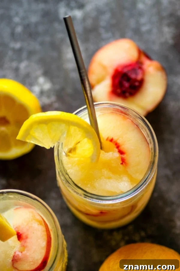 Spiked Peach Lemonade Slush 3 A close-up of a single Frozen Peach Rum Lemonade Slushie, showcasing its icy texture and bright peach color.