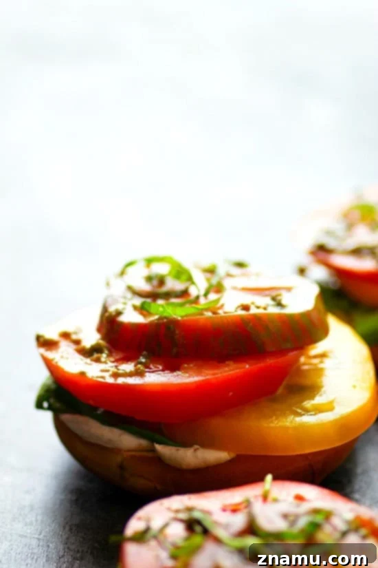 Artisan Heirloom Tomato and Goat Cheese Bagel Toasts 4 A close-up shot of an open-faced bagel sandwich, highlighting the texture of creamy goat cheese spread over a toasted bagel, topped with vibrant heirloom tomato slices. The image focuses on the fresh ingredients, emphasizing the simplicity and deliciousness of the summery dish.