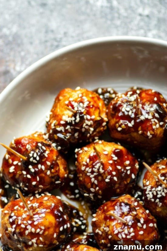 Instant Pot Sticky Honey Sesame Chicken Meatballs 5 Instant Pot Honey Sesame Glazed Chicken Meatballs - Delicious glazed chicken meatballs served in a white bowl with toothpicks, ready for snacking, illustrating the perfect appetizer.